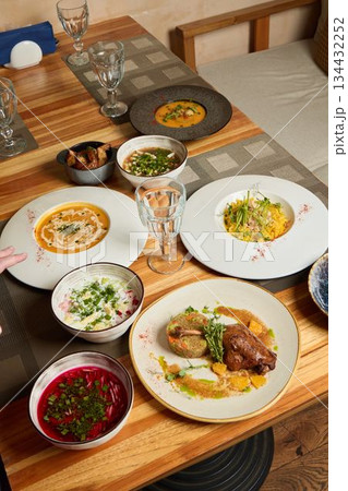 Savoring beautifully arranged dishes on a rustic wooden table is a delightful experience 134432252