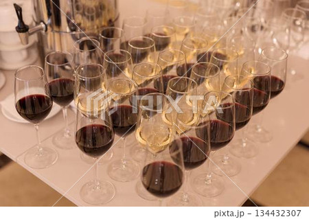 Sophisticated Arrangement Of Crimson Wine Glasses On Pristine Table At Luxury Hotel Reception 134432307