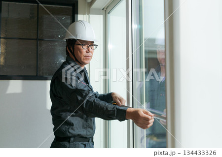 窓ガラスを確認する作業員 134433326