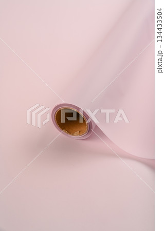 Pastel pink flower wrapping paper roll on a matching soft background used for bouquet packaging and craft decoration with gentle light pink tones. 134433504