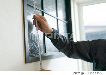 作業服を着た50代男性の手元 134433580