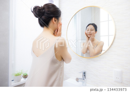 洗面所で鏡を見る若い女性　 134433973