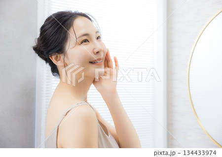 洗面所で鏡を見る若い女性 洗面所で鏡を見る若い女性 134433974