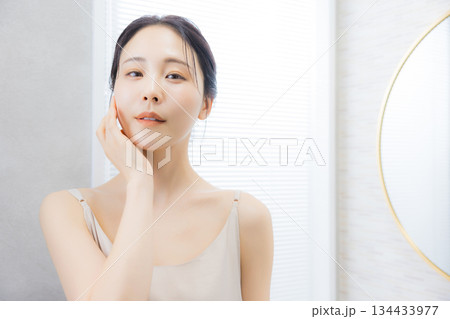 洗面所で鏡を見る若い女性　 134433977