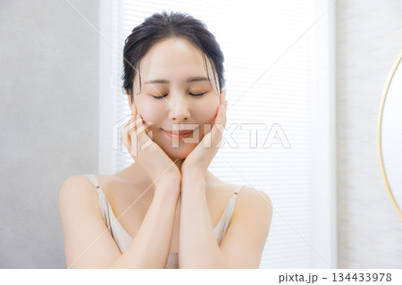 洗面所で鏡を見る若い女性　 134433978