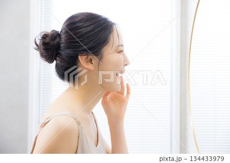 洗面所で鏡を見る若い女性　 134433979