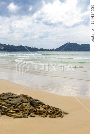 Rocky beach with rocks waves turquoise water in Patong Thailand. 134434559