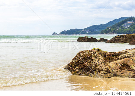 Rocky beach with rocks waves turquoise water in Patong Thailand. Rocky beach with rocks waves turquoise water in Patong Thailand. 134434561