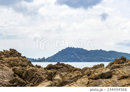Rocky beach with rocks waves turquoise water in Patong Thailand. Rocky beach with rocks waves turquoise water in Patong Thailand. 134434568