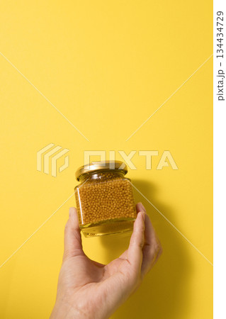 手に持ったマスタードの瓶 134434729