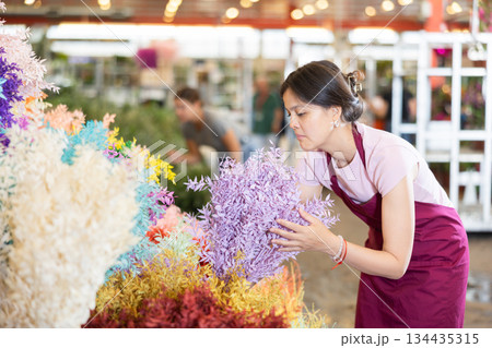 Portrait of female flower market seller with bouquets ruscus italie of flowers Portrait of female flower market seller with bouquets ruscus italie of flowers 134435315