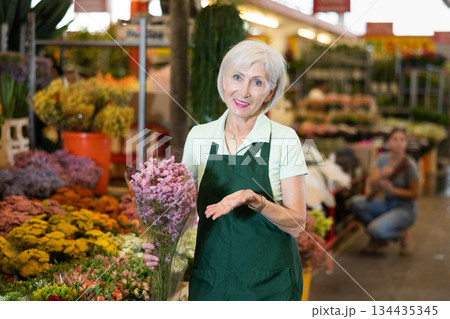 Elderly woman, hostess of the flower market, collects lavender in bouquet Elderly woman, hostess of the flower market, collects lavender in bouquet 134435345
