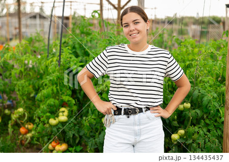 Portrait of young female amateur gardener standing in homestead Portrait of young female amateur gardener standing in homestead 134435437