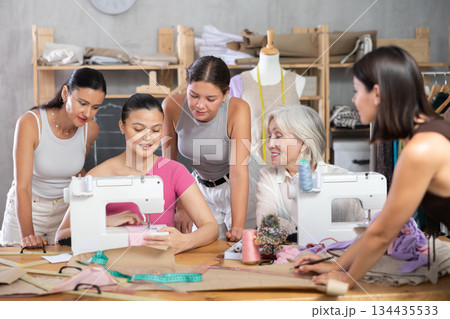 Middle-aged Asian woman showing how to sew Middle-aged Asian woman showing how to sew 134435533