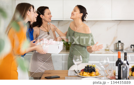 Asian woman greeting friends bringing gift for home party 134435889