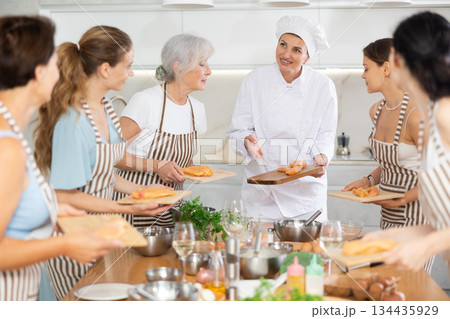 Young woman chef teaches how to cook chicken at master class 134435929