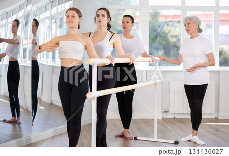 Elderly woman teacher corrects female dancers 134436027