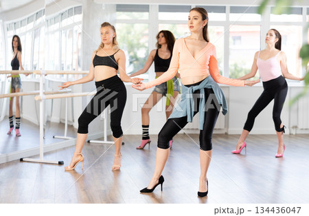 Female dancer practicing jazz-funk dance moves in high heels in studio Female dancer practicing jazz-funk dance moves in high heels in studio 134436047