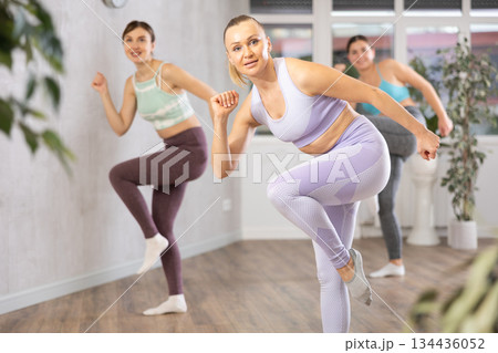 Positive women engaged in active dancing Positive women engaged in active dancing 134436052