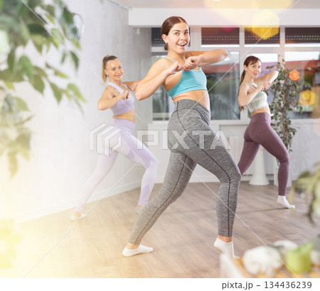 Positive women engaged in active dancing Positive women engaged in active dancing 134436239