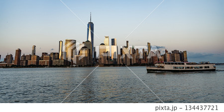 NY city architecture. Midtown Manhattan at Hudson river. Sunset city. Cityscape in sunrise. New York downtown. Manhattan skyline. New York city of USA. Skyscraper building of NYC with touristic boat 134437721