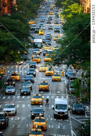 Busy street scene in New York City with many taxis, vehicles, people crossing at traffic Busy street scene in New York City with many taxis, vehicles, people crossing at traffic 134438153
