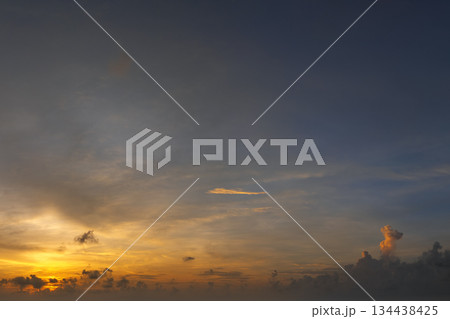 Bright sunset with setting sun behind vivid orange and yellow clouds 134438425