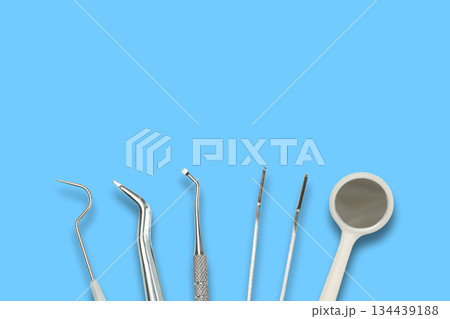 Dental instruments are displayed on a simple blue background 134439188