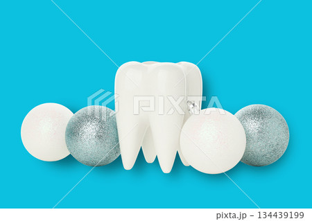 White tooth among festive ornaments on blue background White tooth among festive ornaments on blue background 134439199