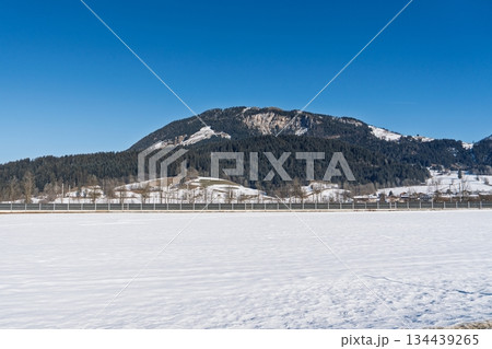 Serene Winter Landscape in Kaprun, Austria Alps A Mountain Backdrop Under Clear Blue Skies Serene Winter Landscape in Kaprun, Austria Alps A Mountain Backdrop Under Clear Blue Skies 134439265