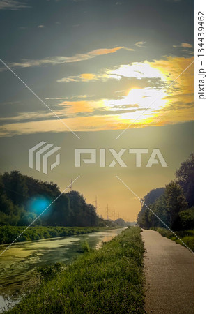 The tranquil serene sunset beautifully illuminates the calm waterway scenic path ahead 134439462