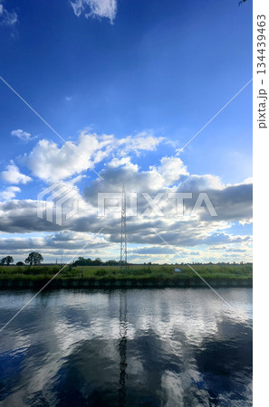 A Serene and Tranquil Reflection of Beautiful Clouds and Lush Landscape Over Calm Water A Serene and Tranquil Reflection of Beautiful Clouds and Lush Landscape Over Calm Water 134439463