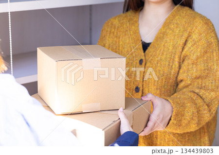 配達員から荷物を受け取る女性 female delivery person 配達員から荷物を受け取る女性 female delivery person 134439803