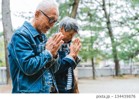 神社で祈願するデニム姿のシニア夫婦 134439876