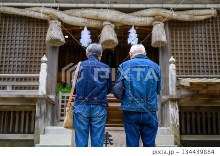 神社で祈るデニム姿のシニア夫婦 神社で祈るデニム姿のシニア夫婦 134439884