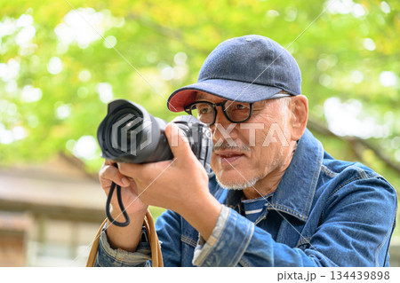 カメラを構えるシニア男性 134439898