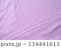 Purple fold knitted fabric background and texture.The fabric features a prominent vertical rib texture. 134441613