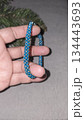 A blue handmade bracelet made of beads and glass beads on a light background. 134443693