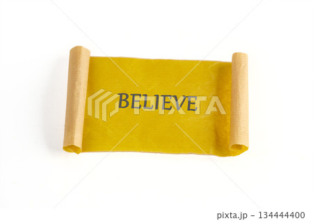 A golden scroll is displayed. The word BELIEVE is written across it in block letters. The paper is aged and rolled on each end to give the feeling of timeless wisdom A golden scroll is displayed. The word BELIEVE is written across it in block letters. The paper is aged and rolled on each end to give the feeling of timeless wisdom 134444400