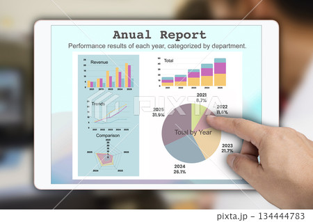 Someone hand pointing to graph of annual report showing on electronic tablet screen. 134444783