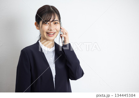 スマートフォンで通話するスーツ姿の若いビジネスウーマン 134445384