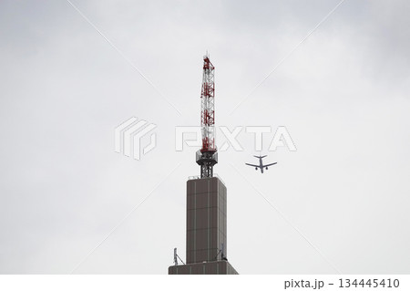 ビル上部に設置されたアンテナと旅客機 ビル上部に設置されたアンテナと旅客機 134445410