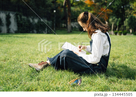 Girl Drawing in Summer Park. Relax lifestyle portrait  134445505