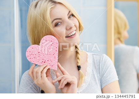 Blonde woman in braids holding heart 134445791