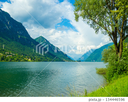 Serene Lake Idro Surrounded by Majestic Mountains and Cloudy sky, Italy, Crone Serene Lake Idro Surrounded by Majestic Mountains and Cloudy sky, Italy, Crone 134446596