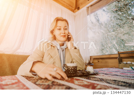 Woman Talking on the Phone in a Cozy Cabin Woman Talking on the Phone in a Cozy Cabin 134447130