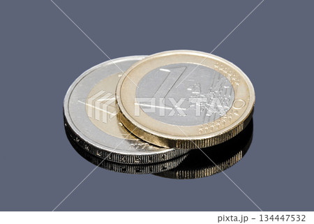 Coins of one and two Euro on a gray background close up Coins of one and two Euro on a gray background close up 134447532