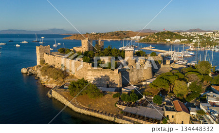 Aerial view of Bodrum Castle and marina on the Aegean Sea in Turkey. Historic stone fortress, harbor with yachts, coastal city landscape and travel destination. Aerial view of Bodrum Castle and marina on the Aegean Sea in Turkey. Historic stone fortress, harbor with yachts, coastal city landscape and travel destination. 134448332