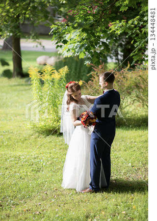 Young wedding couple dancing together on grassy lawn Young wedding couple dancing together on grassy lawn 134448481