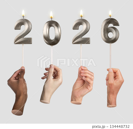 Hands lifting 2026 candle numbers, representing festive spirit, countdown, and happiness of 134448732